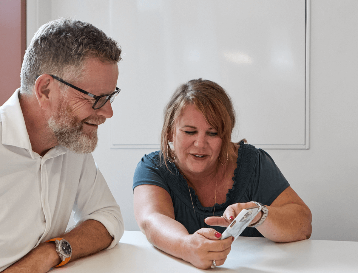 Two colleagues looking at at mobile phone